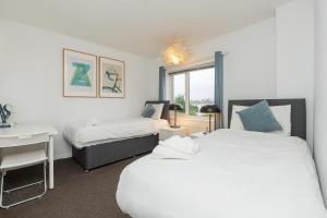 a bedroom with two beds and a desk and a bed and a window at Brett Stays - Middleton Oasis in Avonmouth