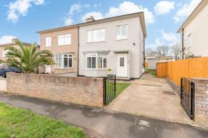 a white house with a fence in front of it at Brett Stays - Middleton Oasis in Avonmouth