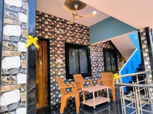 a room with a table and chairs and a stone wall at Lopez Paradise - Honnavar in Honāvar