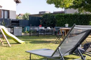 a playground with a slide and a table and chairs at PARADIS CHAMBRES D'HÔTES PROCHE PARIS - AÉROPORT CHARLES DE GAULLE AIRPORT - PARC DES EXPOSITION VILLEPINTE - DYSNAYLAND PARIS. in Tremblay En France