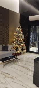 Un árbol de Navidad en una sala de estar con un sofá. en BulevarD Apartment, en Belgrado