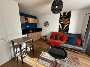 ein Wohnzimmer mit einem Sofa und einem Tisch in der Unterkunft Le Songe bleu - centre ville - netflix in Niort
