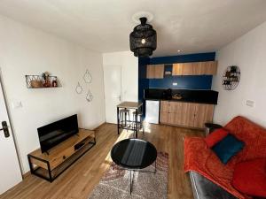 ein Wohnzimmer mit einem Sofa und einem Tisch in der Unterkunft Le Songe bleu - centre ville - netflix in Niort