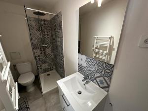 een badkamer met een wastafel, een toilet en een spiegel bij Le Songe bleu - centre ville - netflix in Niort