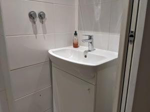 ein weißes Waschbecken mit einer Flasche Seife drauf in der Unterkunft The Ground Floor Suite in Vitry-sur-Seine