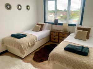 1 dormitorio con 2 camas y ventana en The House of Golf en Fife