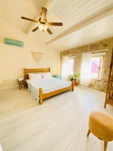 a bedroom with a bed and a ceiling fan at Alaca Butik Otel in Cesme