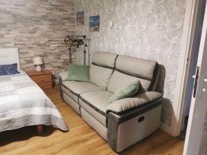 a living room with a couch and a bed at ACCUEIL LAFAYE21 in Orthez