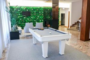 a pool table in a room with a wall of plants at Hotel São Bento da Porta Aberta & Spa in Geres