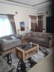 2 bedroom service apartment with full services في Idimu: غرفة معيشة مع كنبتين وطاولة قهوة