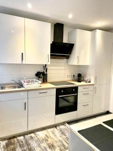 a white kitchen with white cabinets and a sink at DeuxPonts Ferienwohnung in Zweibrücken