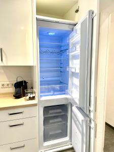 an empty refrigerator with its door open in a kitchen at DeuxPonts Ferienwohnung in Zweibrücken