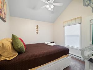 Schlafzimmer mit einem Bett und einem Deckenventilator in der Unterkunft The Riesling Cottage - GOTL Strip - Cozy & Quaint in Geneva