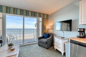 a living room with a television and a balcony at 2501 S Ocean Blvd, 0505 - Ocean Front Sleeps 6 in Myrtle Beach