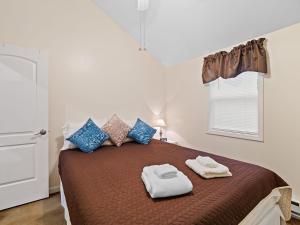 - une chambre avec un lit et 2 serviettes dans l'établissement Chardonnay Cottage - GOTL Strip - Cozy & Quaint, à Geneva