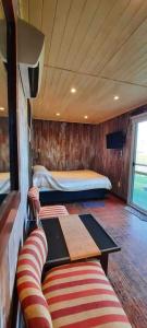 Zimmer mit einem Bett, einem Sofa und einem Tisch in der Unterkunft Alojamiento con pileta en Cañuelas in Cañuelas