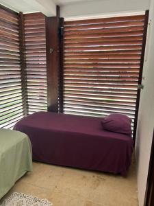 uma cama num quarto com persianas nas janelas em Taiba Beach Resort em Taíba