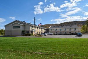 a large building with a parking lot in front of it at Corning Inn in Painted Post