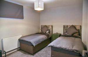 1 Schlafzimmer mit 2 Betten und einem Kronleuchter in der Unterkunft St Edmunds House in Ipswich