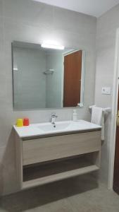 a bathroom with a sink and a large mirror at Apartaments El Sorrall in Blanes