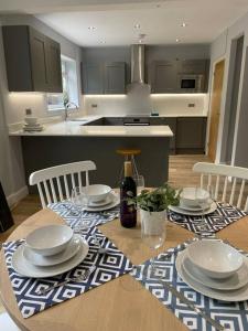 a kitchen with a table with plates and dishes on it at Modern house in leafy suburban Birmingham city in Birmingham