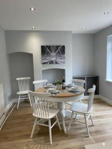 a dining room with a table and white chairs at Modern house in leafy suburban Birmingham city in Birmingham
