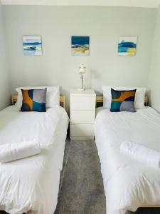two beds sitting next to each other in a room at Modern house in leafy suburban Birmingham city in Birmingham