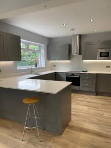 a kitchen with a counter and a stool in it at Modern house in leafy suburban Birmingham city in Birmingham