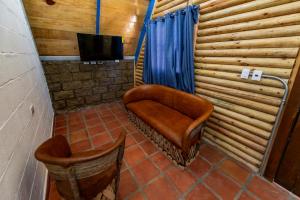 a room with a chair and a television in a room at ÑAÑO V in San Antonio de las Alzanas