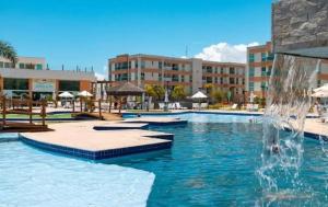 ein Swimmingpool mit Springbrunnen in einem Resort in der Unterkunft Muro Alto Condomínio Clube – Flats completos para a família por Yolo in Ipojuca