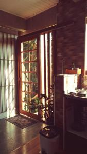uma cozinha com uma porta de vidro deslizante com uma planta em Chalé no morro em Ubatuba