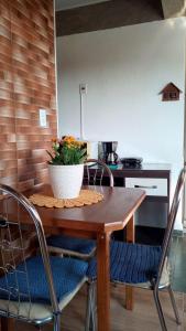 a kitchen with a wooden table with a plant on it at Chalé no morro in Ubatuba
