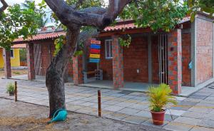 a brick building with a tree in front of it at Casa de temporada 02 -Chalé Portal do Paraíso in Santo Amaro