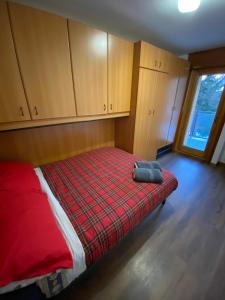 - une chambre avec un lit et une couverture rouge dans l'établissement BeSt Camoscio, à Sestrières