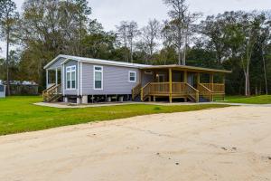 a manufactured home with a porch and a house at Peaceful Starke Retreat with Deck 6 Mi to Downtown! in Starke