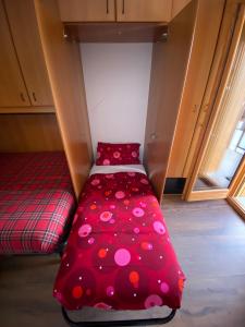 a small room with a red bed with polka dots at BeSt Camoscio in Sestriere