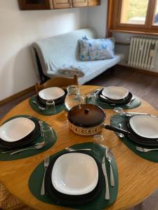 une table avec des assiettes et des ustensiles en haut dans l'établissement BeSt Camoscio, à Sestrières