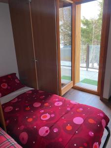 - une chambre avec un lit et une grande fenêtre dans l'établissement BeSt Camoscio, à Sestrières