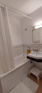 Baño blanco con lavabo y espejo en Cabourg Plage, en Cabourg