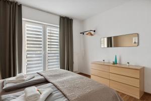 a bedroom with a bed and a dresser and a mirror at Aura - Nula #1 -2 Zimmer, 4 Betten, Küche, Balkon, Waschmaschine in Merseburg