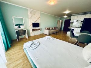 a bedroom with a large bed and a living room at Apartments in Panorama Beach Vigo Nessebar in Nesebar