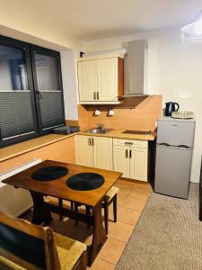 a kitchen with a wooden table and a refrigerator at Willa Irena in Świnoujście