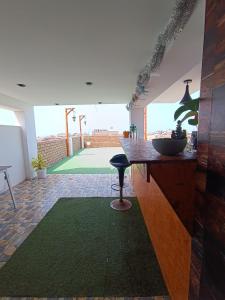 een woonkamer met een aanrecht en een groen tapijt bij Departamento PET Friendly in Chancay