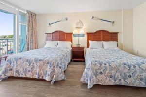 a bedroom with two beds and a balcony at 2501 S Ocean Blvd, 0211 - Ocean Front Sleeps 8 in Myrtle Beach