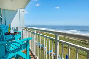 a balcony with a blue chair and the ocean at 2501 S Ocean Blvd, 0211 - Ocean Front Sleeps 8 in Myrtle Beach