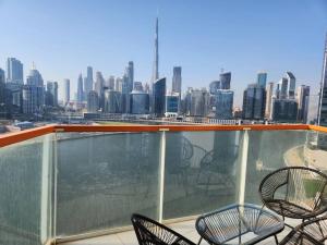 a balcony with chairs and a view of a city at Marasi Moods 2BD on Burj Khalifa and Canal views in Dubai