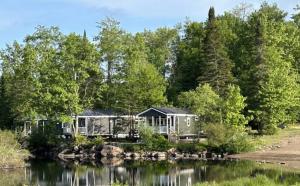 a house on the shore of a lake at HTR Adirondacks in Old Forge