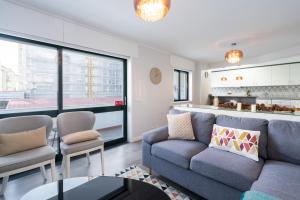 a living room with a couch and chairs and a kitchen at Host Wise - Elegant Spacious Flat w Balcony - Ace Location in Vila Nova de Gaia