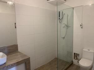 a bathroom with a shower with a toilet and a sink at Hotel Pico Alto, La Planicie in Lima