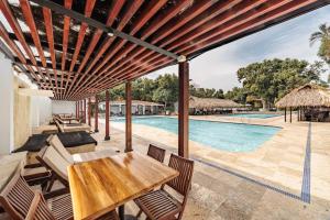 an outdoor patio with a table and chairs and a swimming pool at Hotel Quimbaya in San Jerónimo